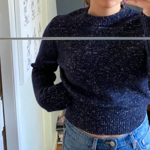 Stickad tröja från COS - Så fin stickad tröja, blå men med vita inslag, aldrig använd och nypris 790kr! Ganska kort i modellen men långa ärmar.