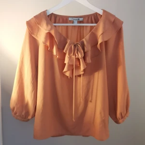Blus från Forever21  - Blus med volanger och knytdetalj i urringningen. Luftigt härligt material. 