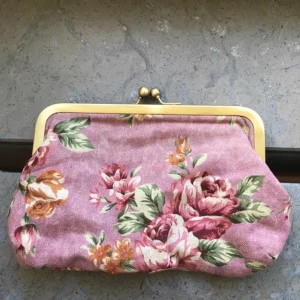  - Söt rosa clutch med rosmönster. 

Insidan är fodrad i ett tyg med orangea och gula små blommor. Den har ett huvudfack samt ett litet fack som stängs med dragkedja.

Köpt för många år sen på Gina Tricot, sen knappt använd och bortglömd i garderoben. Nu är det dags för någon annan att använda den.

Bredd 17 cm
Höjd 13 cm

Jag kan frakta eller mötas upp i Stockholm.
Tar betalt via Plick, swish, kontoinbetalning eller kontant.