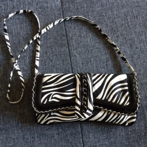  - Zebraväska som funkar som kuvertväska då remmen går att ta av. Liten kedja följer också med. Aldrig använd, bara hängt i gadderoben. Köpt utomlands. Kan skickas eller mötas upp i Malmö. 