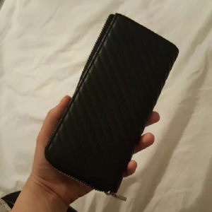  - Stilren plånbok med ett myntfack och har 8 kortfickor