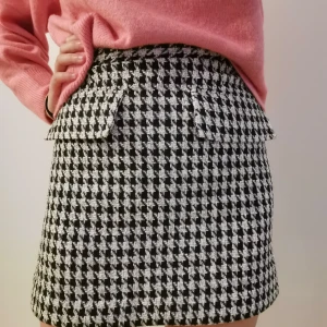 Höst-/vinterkjol  - Säljer en kjol i tjockare tyg med svart/vitt mönster. Storlek 38 men jag upplever den som liten i storleken. 