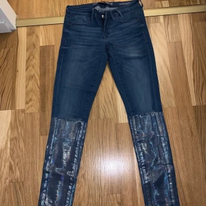 Guess jeans - Snygga guess jeans i storlek 26. Häftiga detaljer med hål i knäna och ”glitter” nedtill. (Nypris ca 1000kr). Knappt använda! 