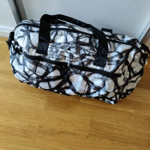 Träningsväska från SOC - Mönstrad träningsväska från SOC Stadium. Stort fack med två mindre inuti. Tre små fack på utsidan. Använd ett fåtal gånger. Skickar spårbart med PostNord. 