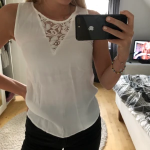 Vit blus med blommig detalj (Oanvänd!!) - Ännu ett plagg som är helt oanvänt. Toppen har aldrig kommit till användning så har valt att sälja den. Märket är Only i storlek 34. Super bra skick!