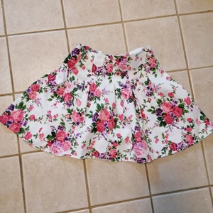 FB sister blommig kjol - Verkligen en jättesöt kjol! Säljes endast då den är för liten för mig. Dragkedja bak. Bra skick, använd några gånger. Hund och katt finns i hemmet. 80kr + frakt 