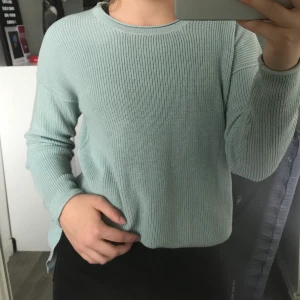 Tröja - En turkos stickad och jättefin tröja med en slitts längst ner. Materialet är inte alls stickigt och tröjan är nästan i nyskick. 60kr + frakt (tar bara swish).