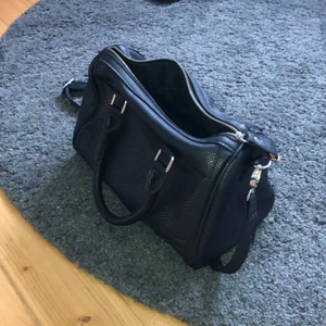 Svart väska med små detaljer - Fin oanvänd svart väska! Med både handtag och band. Bra med utrymme och en liten innerficka💕 Frakt tillkommer!!