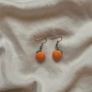 Handgjorda peachörhöngen i lera🍑 - kontakta mig vid intresse!                                                                               pris: 29kr + frakt (om du inte vill mötas upp)                                           mått: själva persikorna är 1 cm