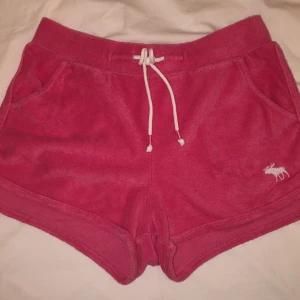 Rosa handduksshorts i bra skick! - Rosa handduksshorts, perfekta att ha efter en bastur på stranden 🏖 I storleken för åldrarna  11/12 för barn  från abercrombie & fitch men skulle säga att den går att använda för ungdomar med storleken XS, då den passar mig (jag har storlek XS)😍