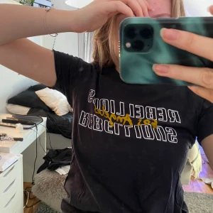 T-shirt med tryck - Grå t-shirt från Gina Tricot med ett vitt och gult tryck, inte använd på säkert ett år och nu säljer jag den