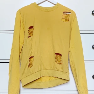 Långärmad tröja  - En sweater med klippta hål (hålen är med i originalplagget). Fräsch gul färg och baggy passform. Passar S-M beroende på hur man vill att den ska sitta. Sparsamt använd💕 Pris kan diskuteras och köparen står för frakt❣️