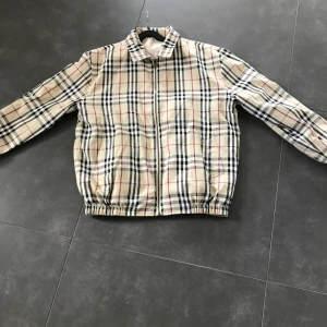 Burberry Nova Check Reversible strl M - Vintage jacka från Burberry London som tyvärr är förliten för mig. Det finns inga synliga flaws och är i mycket bra skick.  Kan mötas upp i Sthlm i helgen eller så fraktas den spårbart mot betalning.Plagget är unisex.Buda i kommentarern,avslutas fre 15.00