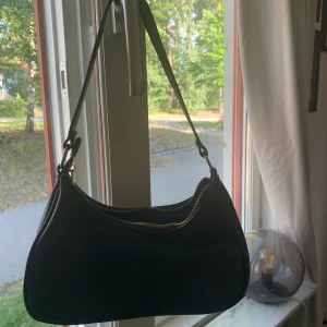 Svart populär axelväska från don Donna  - Säljer nu min favvo väska!! Perfekt till alla tillfällen då den är praktisk men också väldigt snygg som detalj, mycket sparsamt använd. Köpt för 499. Många intresserade så buda😊
