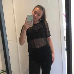 Genomskinlig svart topp - Supersnygg genomskinlig svart topp från Nelly. Supersnygg på fest med en snygg svart bh under, kavaj och ett par kostymbyxor nedtill! 30 kr +frakt. 