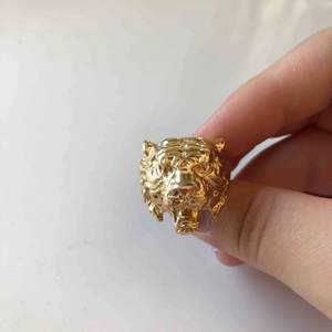 Guldig ring som ser ut som ett lejon 