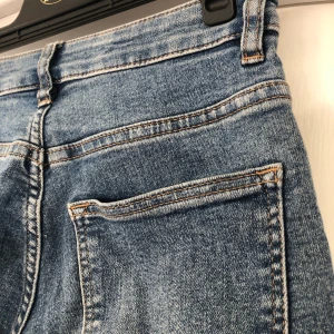 Blå jeans - Fina högmidjade jeans från H&M i stretchig material. Färgen är som på första bilden. Nya kostade de 199kr. Köparen betalar frakt☺️