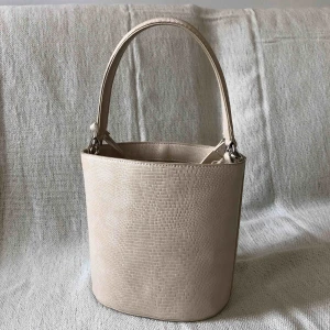  - Benvit/ljus beige liten men rymlig bucketbag.  Hämtas upp i Stockholm eller köpare står för frakt.