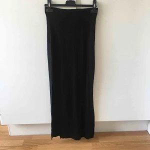  - Svart långkjol med resår i midjan och slits på båda sidorna. 