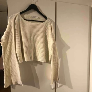  - En vit stickad tröja med vida armar. Storlek xs men passar s med.
