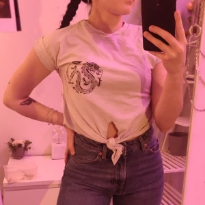 Crop top - Vit crop top med draktryck från reclaimed vintage. Använd få gånger. Frakt tillkommer!