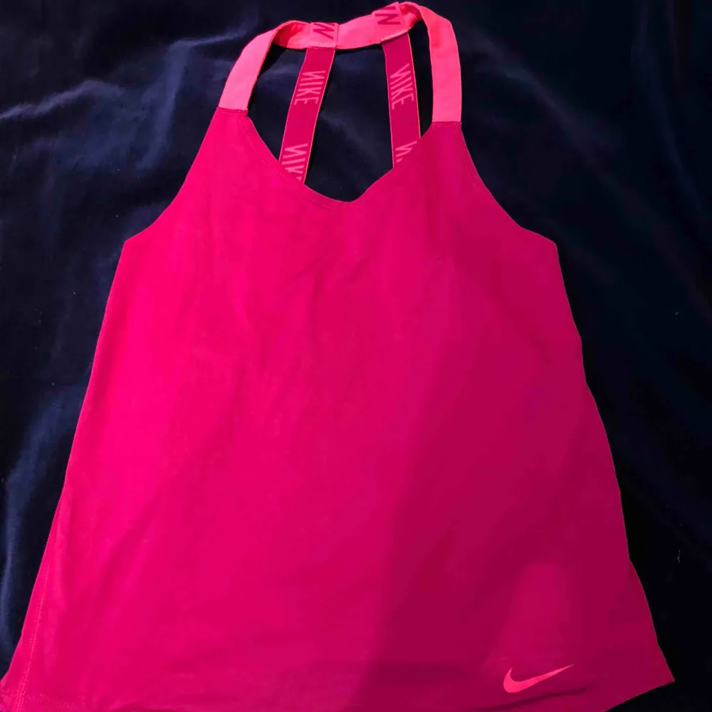 Ett lila/rosa tränings linne från Nike med en låg urringning vid ryggen. Den är i bra skick och är använd ett fåtal gånger:). Toppar.