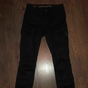  - Ett par tajta mörkblåa Cargo byxor från G-star, köpta för ett år sedan och använt bara 4 gånger. De är i bra skick!