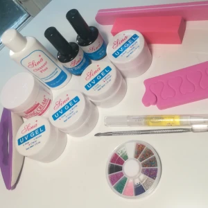  - Nagelkit för Gelenaglar (allt är oanvänt) 200 kr för allt på bild 1 & 2💅🏼✨ Detta ingår: ▪️2 primers och 1 topcoat      ▪️Cleanser  ▪️3 uv gel i färgerna genomskinlig, rosa och vit. ▪️Buffing cream ▪️Filar och tåseparerare                         ▪️Dekorationsstenar ▪️Nagelolja och nagelbandsverktyg    Går även att köpa till genomskinliga Tippar med ballerina form och lim för 50 kr. 
