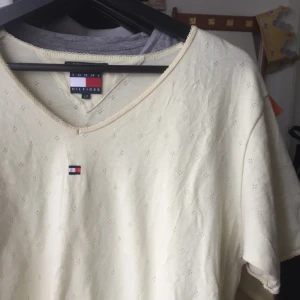  - Supersnygg vintage Tommy Hilfiger t-shirt i ljusgul med inbroderad logga!   Säljer stora delar av min garderob pga flytt! Spana gärna in mina andra saker som ligger uppe.  Betalning sker via Swish, möter gärna upp i Göteborg annars bjuder jag på frakten! 