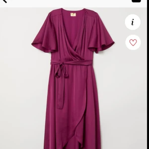  - En lång klänning i satin. Klänningen är V-ringad och har fast omlott fram. Kort trumpetärm. Avskuren i midjan med resår och knytband. Asymmetrisk skuren kjol. Dubblerad upptill och kort underkjol. Har haft den på mig i några timmar bara. Nypris 599:- 