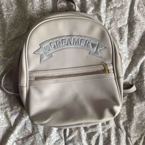  - Lila ryggsäck med testen "dreamer". Använd ett fåtal gånger. Vid frakt är det köparen som står för fraktkostnaden.