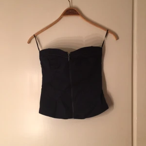  - Mörkblå bustier med dragkedja framtill. Den är ganska stretching med resår baktill. 