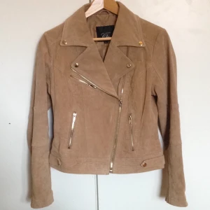  - Helt oanvänd! Säljs pga för stor storlek. Äkta skinn (mocka). Nypris 699kr. Detaljer i guld, fickor fram. Dragkedja på sidan. Utmärkt vår/höstjacka, skinn håller många säsonger :)