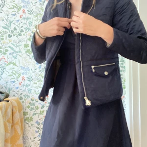 Jacka tunn - En tunn vårjacka som är quiltad. Snygga guldiga detaljer. Går att dra åt baktill för en mer figursydd passform. Sparsamt använd.