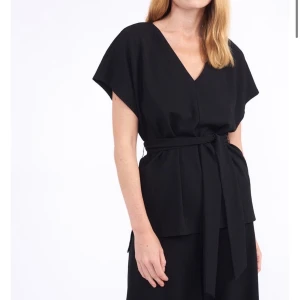 Svart top med knytband - Använd en gång. Svart top med knytband i midjan 