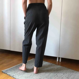  - Gråa kostymbyxor i storlek 38 (men jag har strl 36 och dom sitter lagom på mig). typ ”mom jeans” modell. Gott skick.