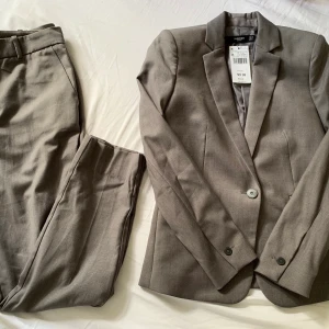 Grå kostym 34/36 - Säljer min helt oanvända mango kostym i grått! Kavajen är i storlek 34 och kostymbyxorna i storlek 36. Väldigt snyggt till fest eller andra tillställningar! Om ni vill ha fler bilder är det bara att skriva🌼 Köparen står för frakten! 