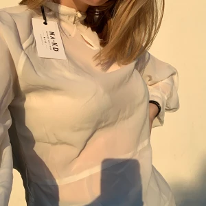 Nakd blus - En vit blus från Nakd. Kommer med ett fint band som man kan knyta runt midjan för att få lite passform. Helt oanvänd med prislappen kvar🥰