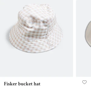 Vändbar bucket hat - Säljer denna supergulliga vändbara bucket hatten! Rosa-rutig på ena sidan och vit på andra, säljs då den var för liten på mig. OANVÄND!