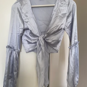 Satintopp - Blå satintopp från ginatricot i strl 36, passar XS/S. Använd någon gång. Kan mötas upp i Västerås annars står köparen för frakt.