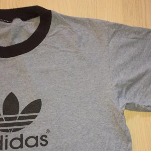 vintage adidaströja - ljusblå/grå adidaströja. mycket bra skick (dock ingen storlekslapp, skulle gissa på M/liten L). från 80 talet då min pappa var ung :)) HÖR AV ER VID FRÅGOR!! om fler är intressserade blir det budgivning