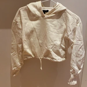 Hoodie - En croppad hoodie i beigevit. Från LA.hearts i storleken xs. Exklusive frakt