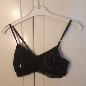 Paljett-topp - Svart paljett-topp med spetsdetaljer. Gott skick förutom några små noppror på spetsen och två små trådar. Priset är exklusive frakt, kan både mötas upp i Göteborg och skicka. Obs katt finns i hemmet!