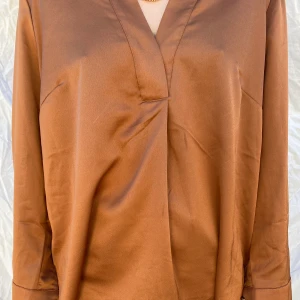 Guldig skjorta🤎 - En fin skjorta med knappar i ärmarnna och v-ringning. +frakt💖