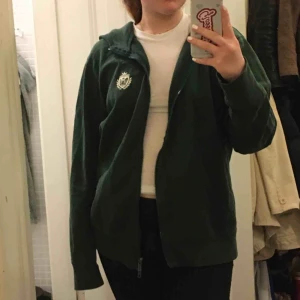  - Grön tjocktröja med huva och tryck på ryggen. Gott skick. Möts i innerstan/köparen står för frakt.