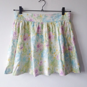 Blommig kort kjol med hög midja och knappar. - Blommig kort kjol med hög midja och knappar.