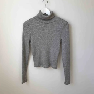  - En grå polotröja i mycket fint skick. Köparen står för fraktkostnad enligt postens portotabell.