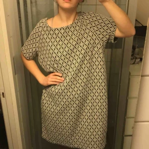  - Härlig svartvitmönstrad klänning från indiska i skönt tjockt material. Sparsamt använd och utan skavanker. Frakt inom Sverige ingår.