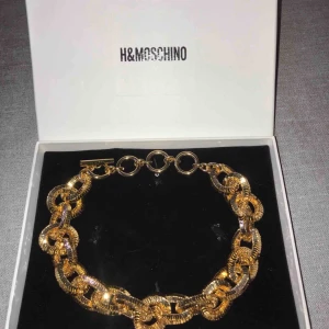  - SÄLJS PÅ TRADERA! En helt oanvänd MOSCHINO [TV] H&M Guldpläterad halsband. Legat i asken sen jag köpte den. Riktigt fint halsband som inte går att köpa längre då det såldes slut på direkten!  -Jag tar inte ansvar för postnords hantering. 