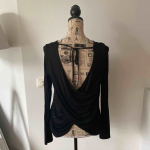  - Snygg svart topp med djup ringning i ryggen.